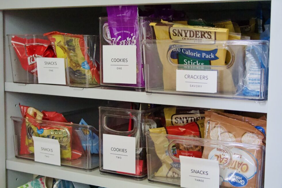 Organized pantry with labeled bins for snacks, cookies, and crackers